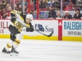 December 23, 2018: Boston Bruins defenseman John Moore (27) takes a shot in the second period of the NHL game between the Boston Bruins and the Carolina Hurricanes at PNC Arena in Raleigh, NC. Jonathan Huff/CSM